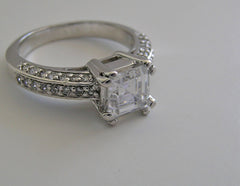 FEMININE RING SETTING FOR PRINCESS SHAPE STONE SET WITH ROUND DIAMONDS